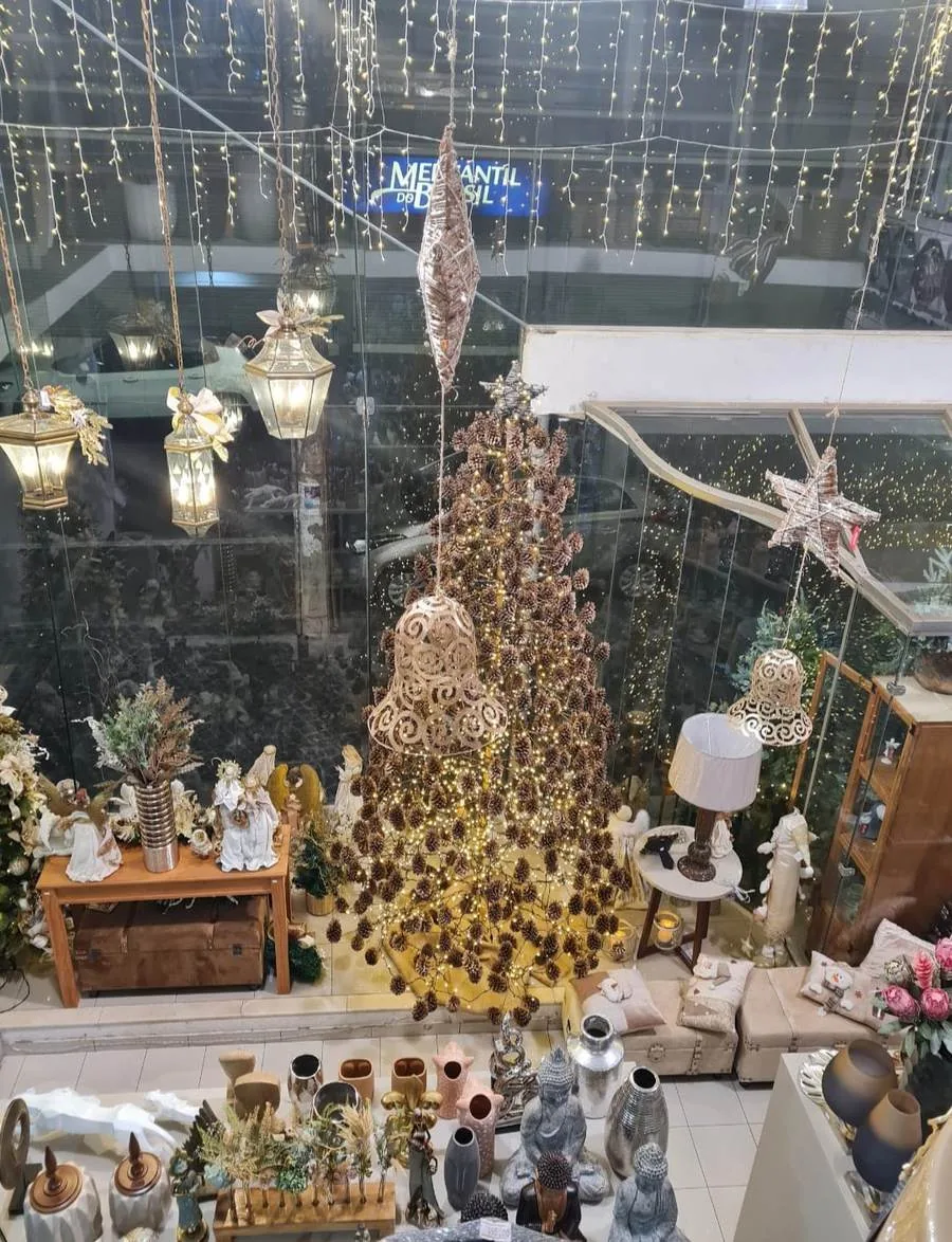 Árvore de Natal feita de pinhas, montada à mão no vão central da loja