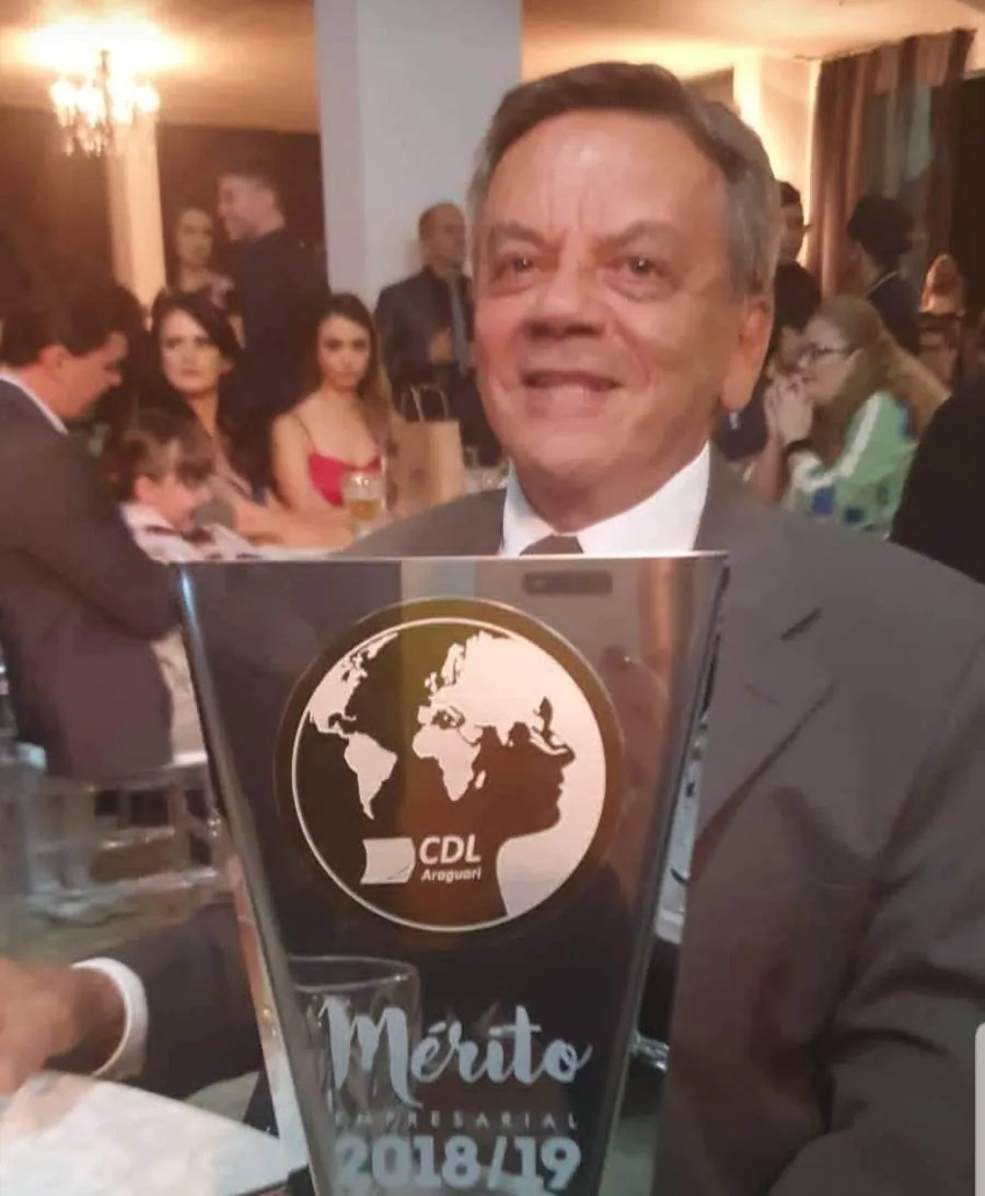 Djalma com a placa do Mérito Empresarial da CDL Araguari nas mãos, na noite da entrega